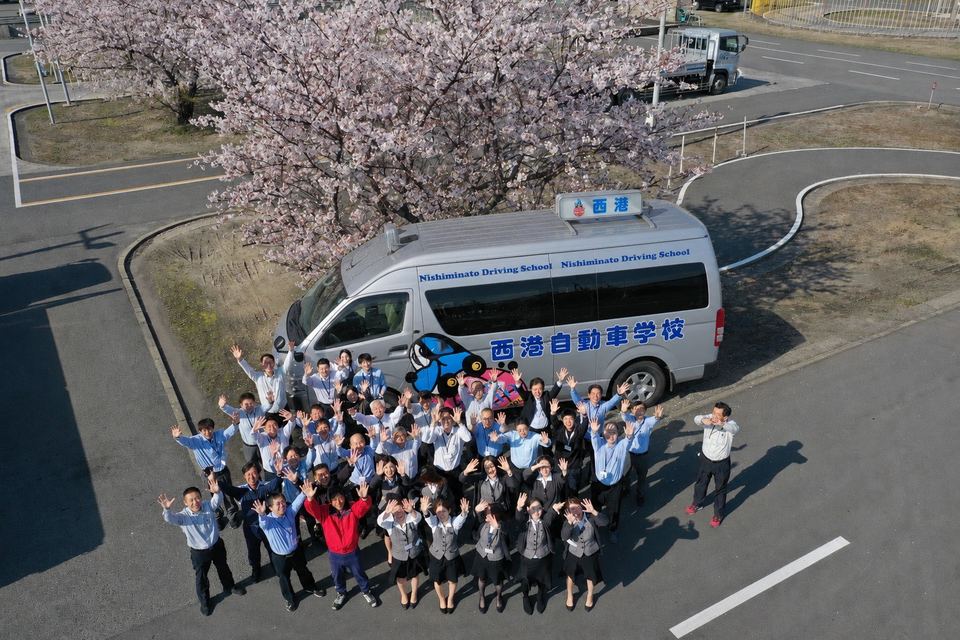 西港自動車学校のスタッフと送迎バス